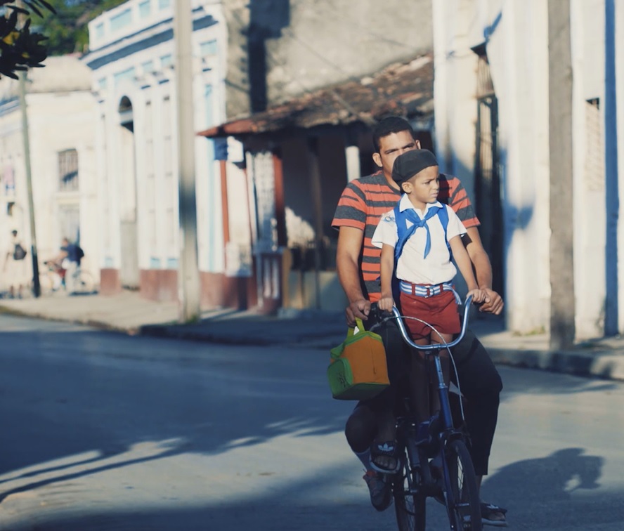 Pionero en bicicleta con su padre.Cienfuegos.CubaTravel Pionero en bicicleta con su padre.Cienfuegos.CubaTravel